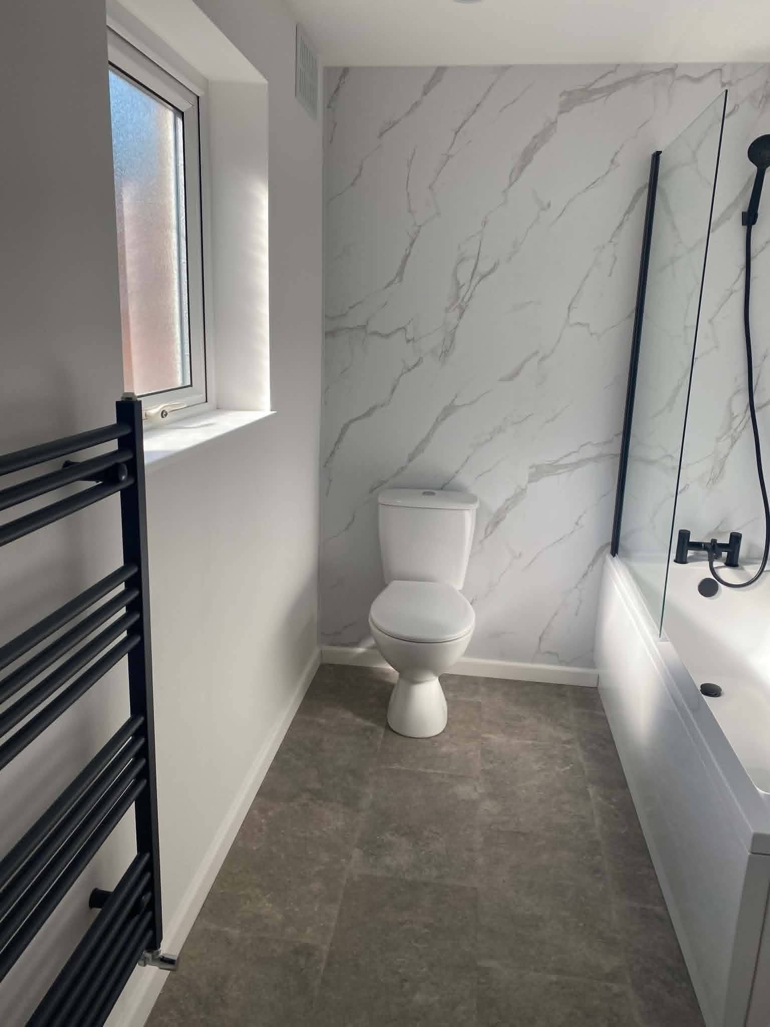 White bathroom with marble feature wall