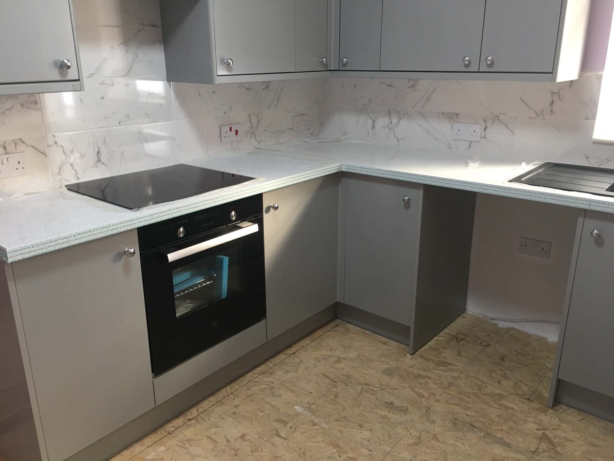 Grey fitted kitchen with marble splashback